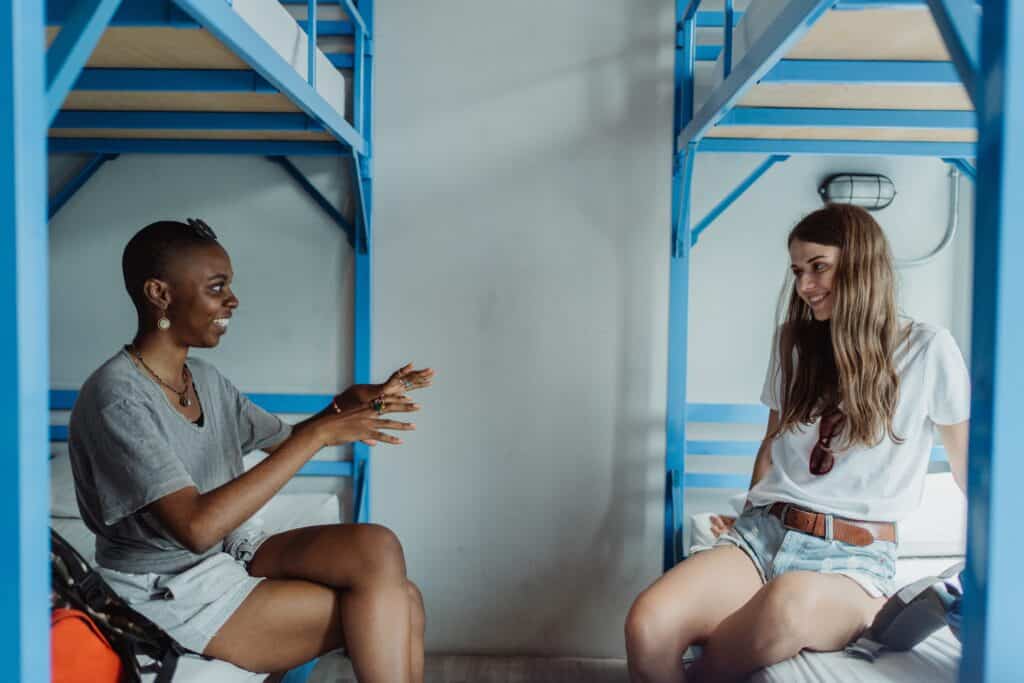 A picture of two friends talking in a hostel. One of the reasons I answer yes to "are hostels safe?" is that you can meet new people to trust. 