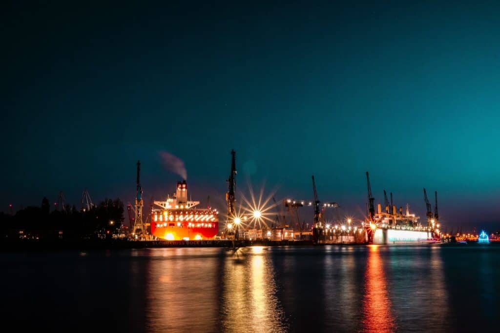 A picture of Hamburg's harbour at night with lights from the ships and port. Hamburg boat tours are made even more special by being in the dark with the lights glowing. 