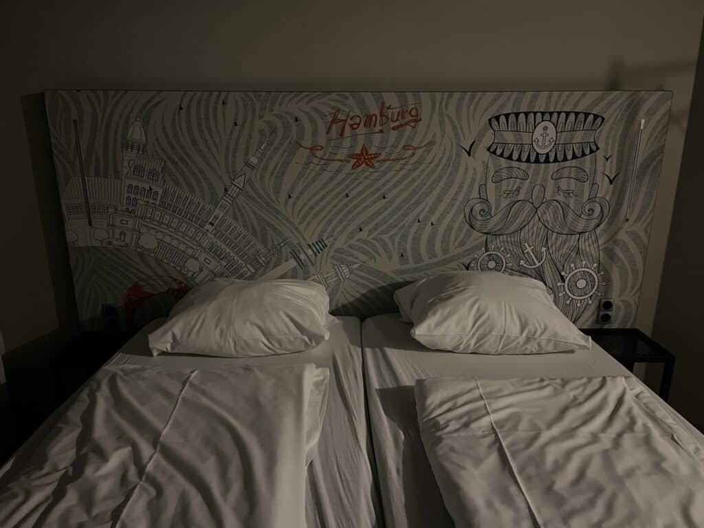 A picture of our beds in A&O Hostel Hamburg Hauptbahnhof with a headboard with Hamburg illustrations on it.