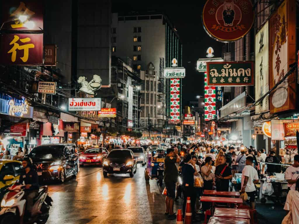 A picture of a busy street in Bangkok at night.